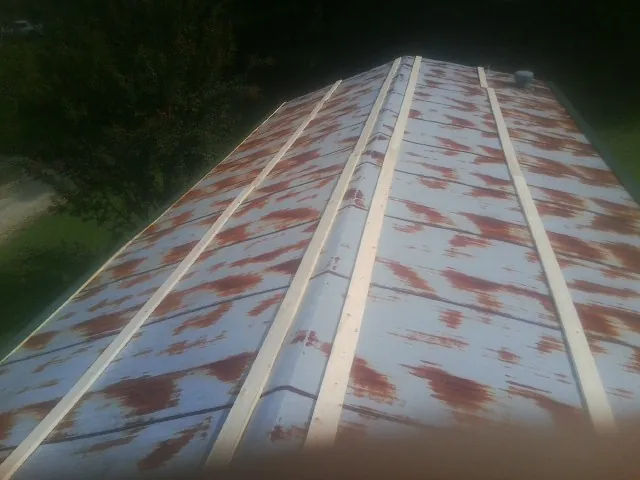 Rusted metal roof panels with new wood purlins before replacement — Storm Damage Roof Repair in Christiansburg by Roofing Brothers