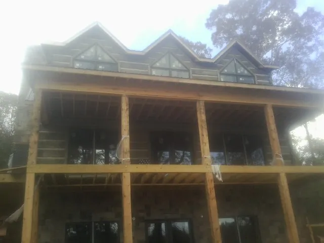Dormers and porch framing on a large log home under construction — Roof Coating work by our crew in Christiansburg