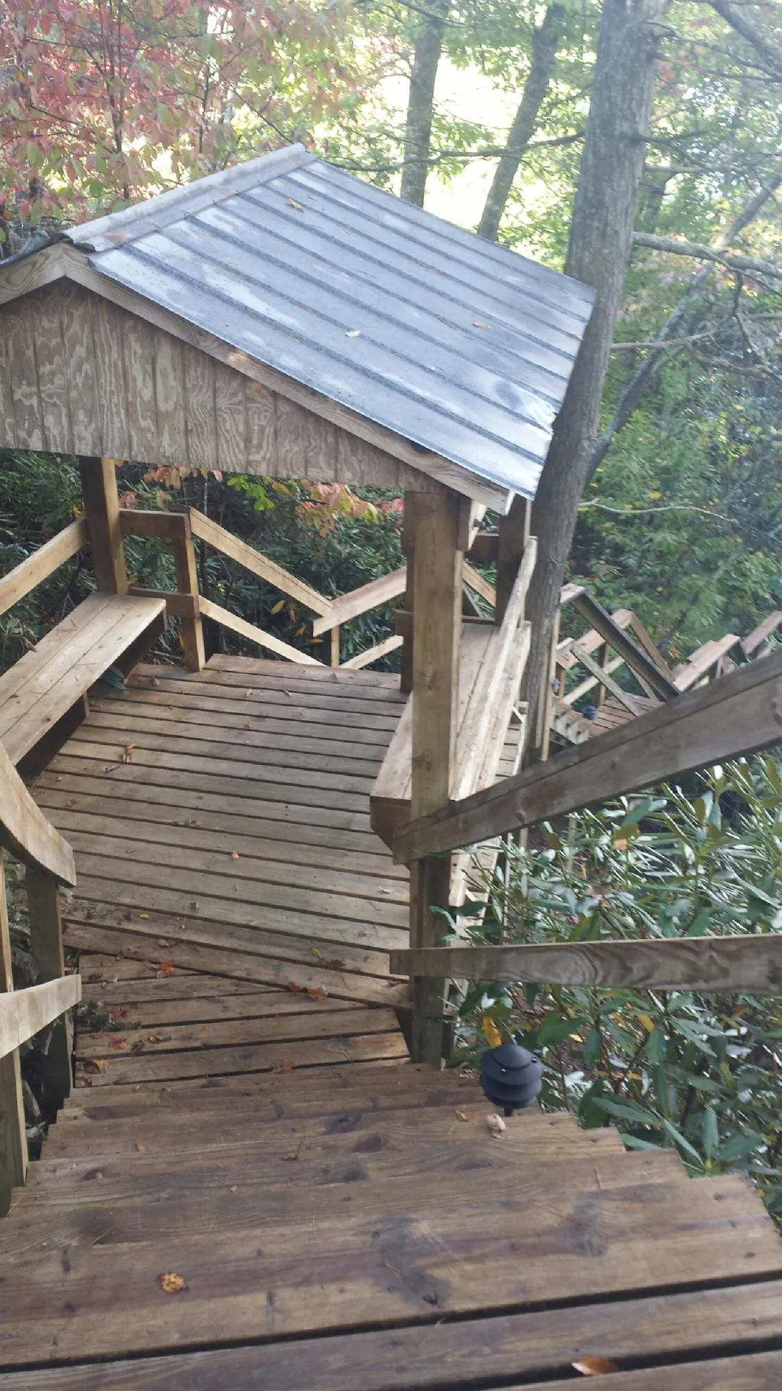 Metal roofed shelter over wooden steps on a wooded walkway — Skylight Repair & Installation work by our crew in Christiansburg