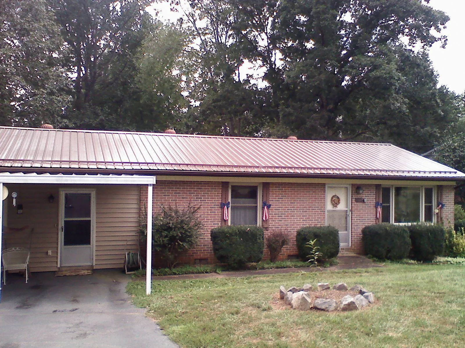 Bronze metal roof and carport on a brick ranch home — Roof Repair work by our crew in Christiansburg