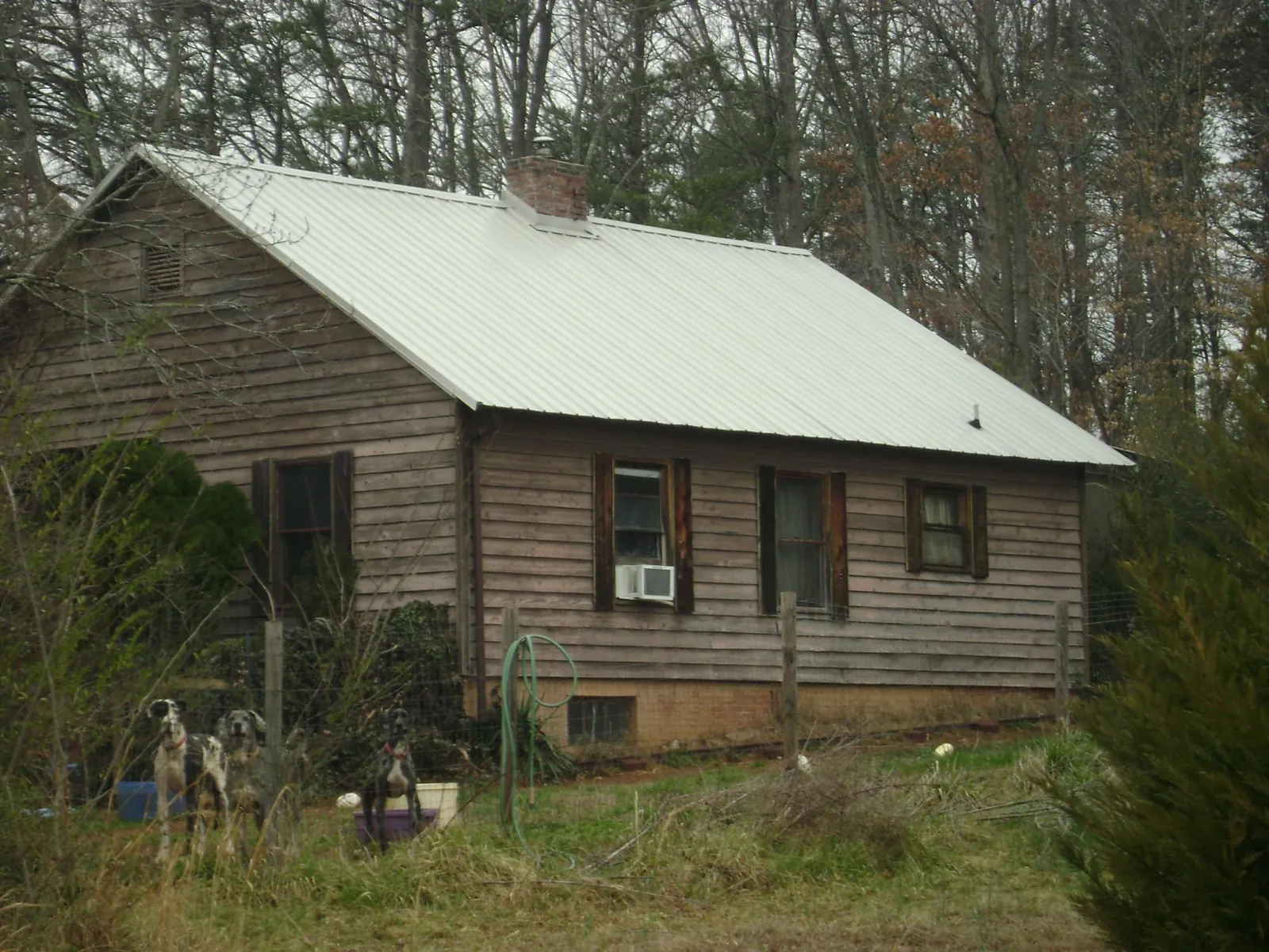 White metal roof on an old wood sided farmhouse, from a Asphalt Shingle Roof Repair job in Christiansburg